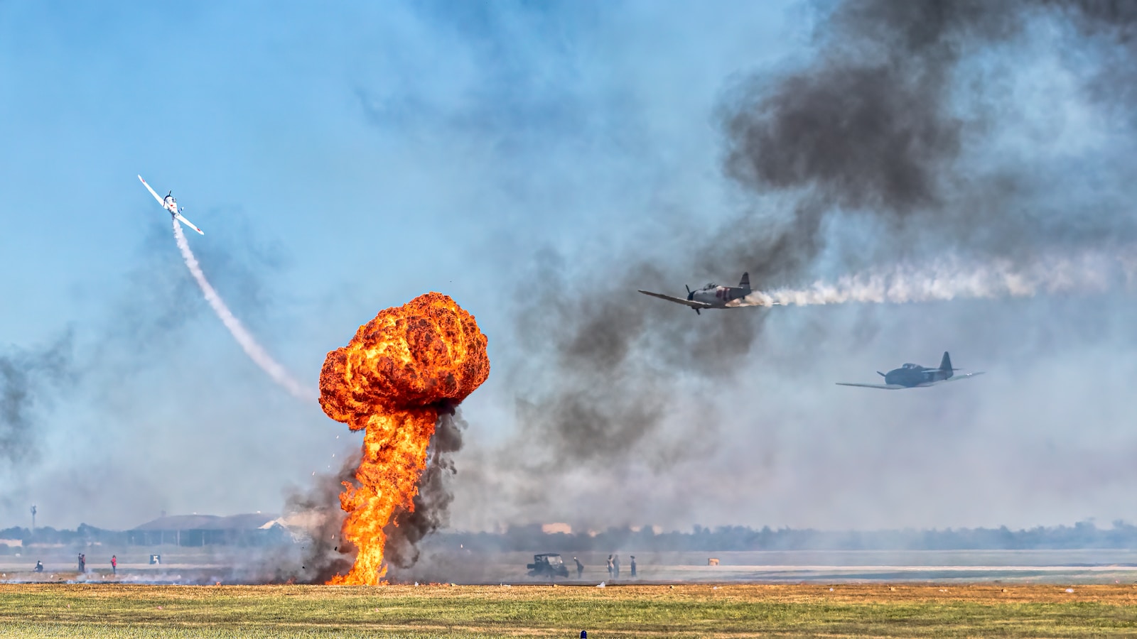 a plane is flying in the sky near a large explosion